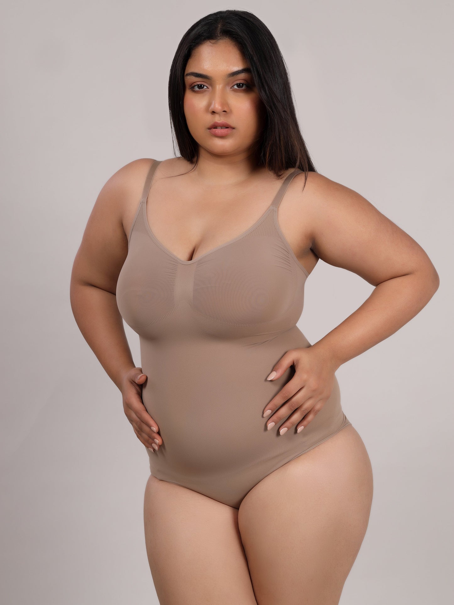Beige tummy control bodysuit worn under fitted outfit by Sottura